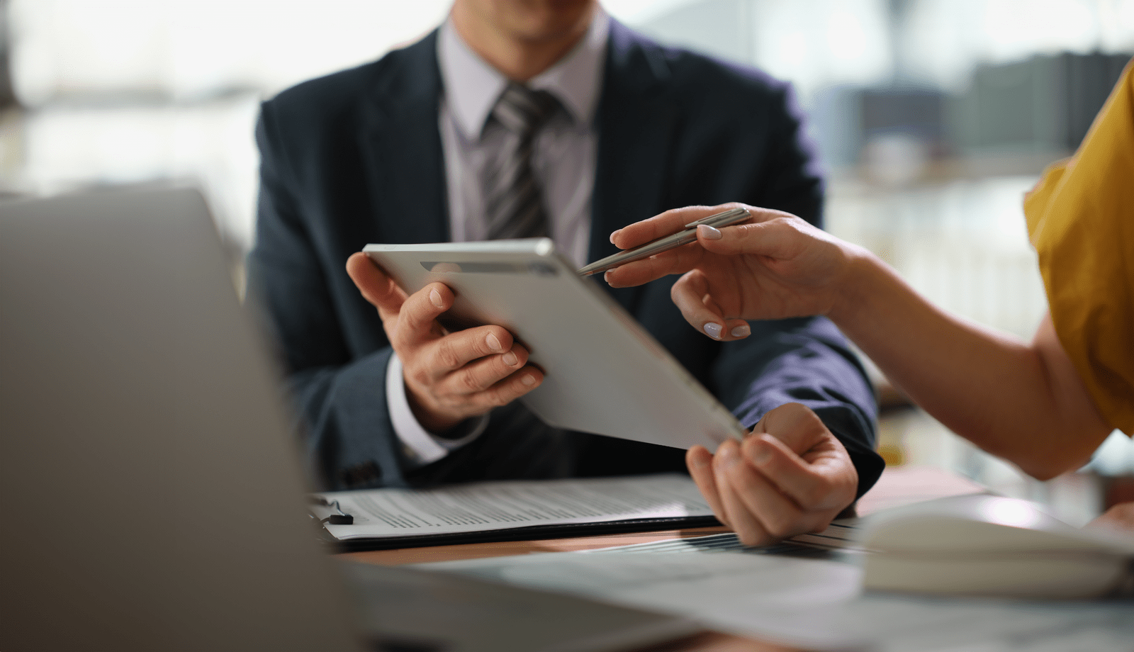 Two people reviewing a document on a tablet